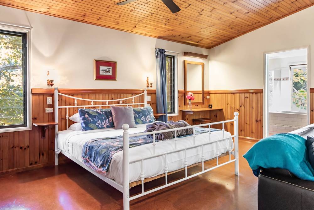 King-size bed with timber headboard and metal frame in cabin bedroom
