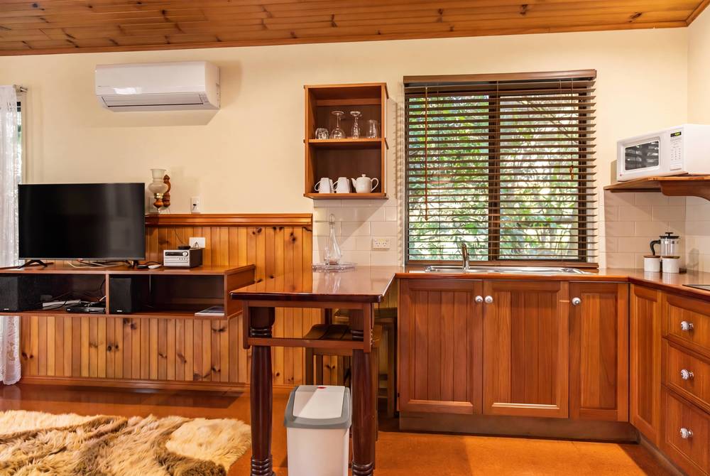 Timber kitchen with wooden cabinetry, shelving and rainforest view