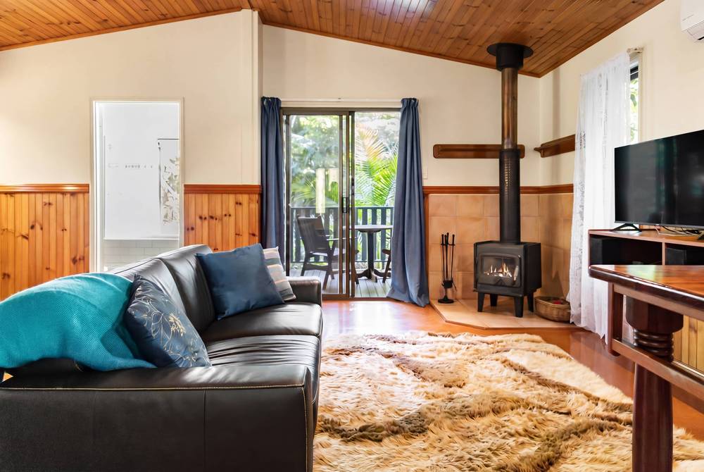Cabin living room with wood stove, leather seating and timber finishes