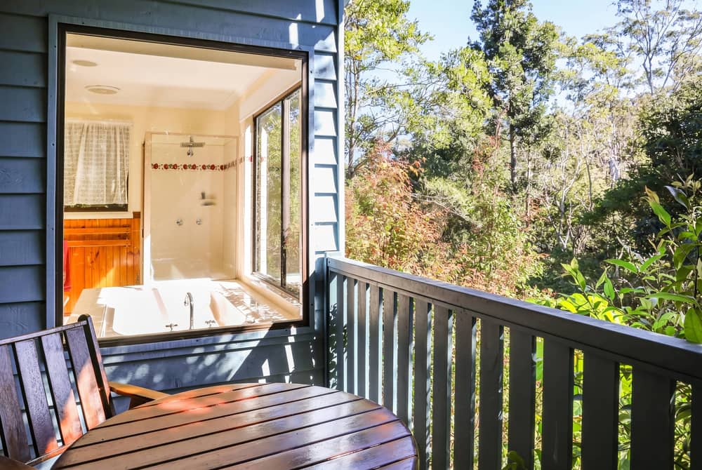 King-size spa bath on a cabin verandah looking straight out into the rainforest