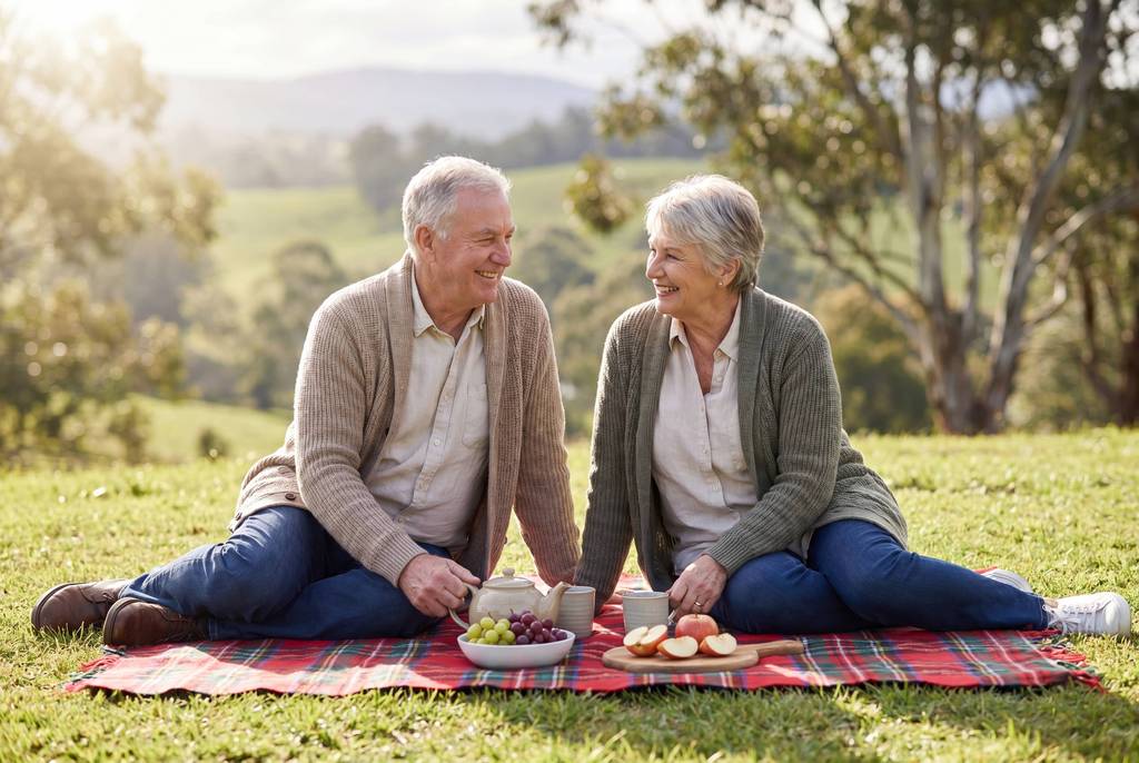 A couple picnicking on a blanket with a hinterland view