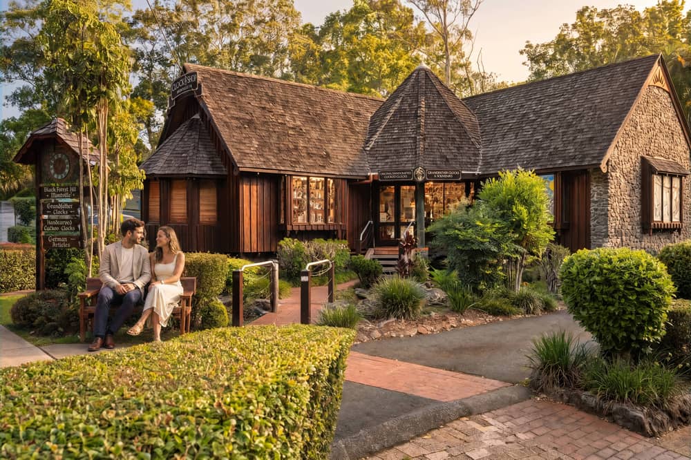 The Clock Shop building with dark-timber cladding and manicured gardens in the village