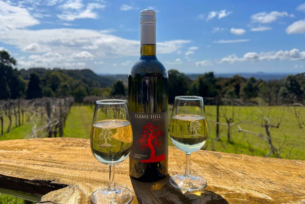 Wine and glasses overlooking the Flame Hill vineyard